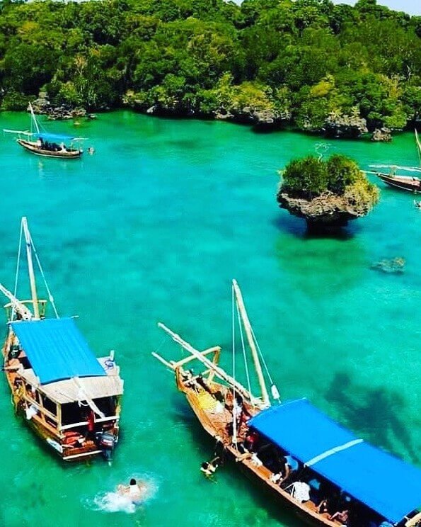 Safari Blue boat with tourists snorkeling in turquoise waters off Zanzibar